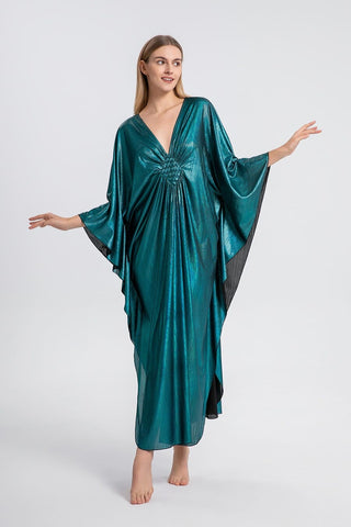 A woman wearing a green sparkly glitter maxi kaftan dress.