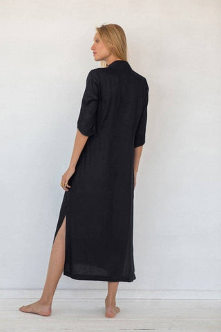 A woman wearing a black long kaftan cover up.