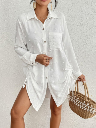 A woman wearing a bathing suit blouse button down shirt.