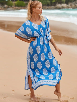 A woman wearing a blue v-neck kaftan dress at the beach.