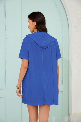 A woman wearing a blue zipper swimsuit coverup with pockets.