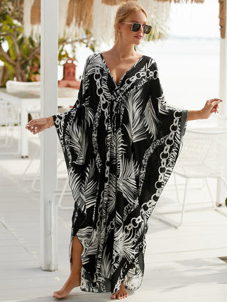 A woman wearing a feather print V-neck kaftan dress.