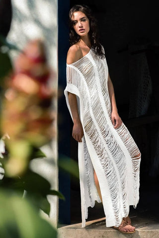 A woman wearing a white side split crochet cover up.