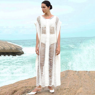 A woman wearing a white side split crochet dress.