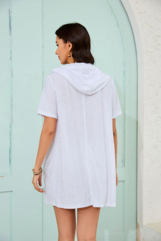 A woman wearing a white zipper hooded swimsuit coverup.